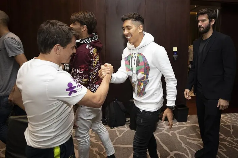 Roberto Firmino cumprimenta Juninho Paulista na chegada ao hotel da Seleção