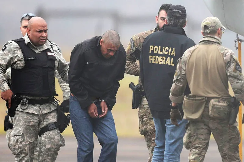 Federal Police agents escort Adelio Bispo de Oliveira, suspected of stabbing Brazilian presidential candidate Jair Bolsonaro, to transfer him to a federal prison in Campo Grande, Mato Grosso state, at Francisco Alvares de Assis airport in Juiz de Fora, Brazil, September 8, 2018. REUTERS/Ricardo Moraes
