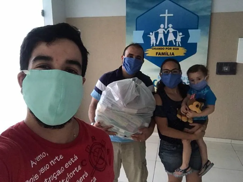 De máscara, pastor Wenbley, com a esposa, Rafaela, o filho e o coordenador da campanha, Pedro Osano, tem recebido cestas de alimentos