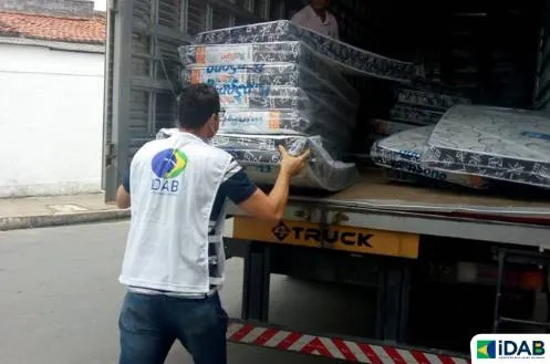 Funcionário do Instituto Diva Alves carrega caminhão com colchonetes para serem doados no interior de Alagoas