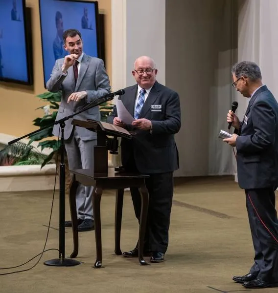 Geoffrey Jackson (c), membro do Corpo Governante, durante programa de lançamento da Bíblia em ASL em 2020