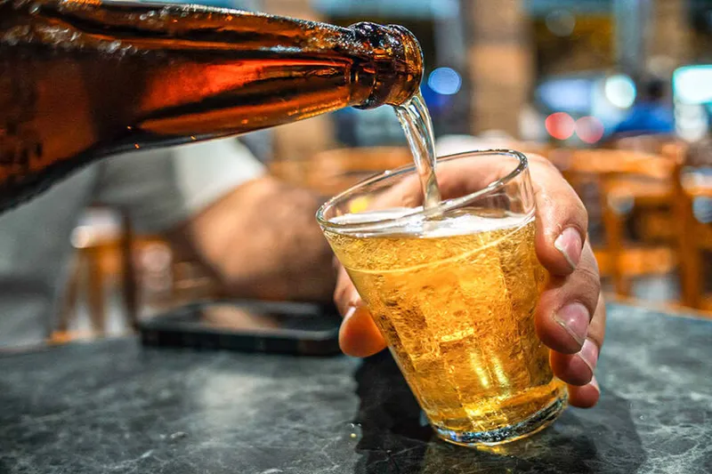 A man pours beer into a glass in a Brazilian bar.