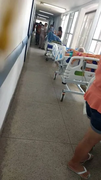 Pacientes alojados em leitos improvisados nos corredores formam uma imagem frequente