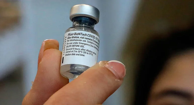 (FILES) In this file photo taken on February 22, 2021 a paramedic with Israel's Magen David Adom medical services displays a vial of the Pfizer-BioNTech COVID-19 vaccine at an IKEA branch in the Israeli city of Beit Shemesh. - The Brazilian Health Regulatory Agency approved US laboratory Pfizer's vaccine against Covid-19 for widespread use on February 23, 2021, even though the immunizer is still not available in the country. (Photo by AHMAD GHARABLI / AFP)