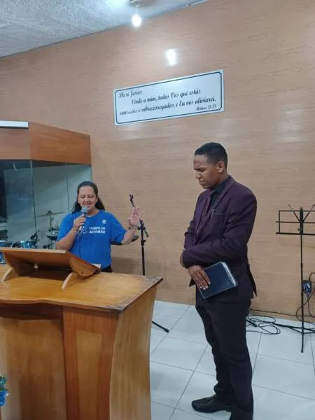 Diaconisa Patrícia Costa no momento em que orava com o irmão Janilson Santos, um dos palestrantes do evento