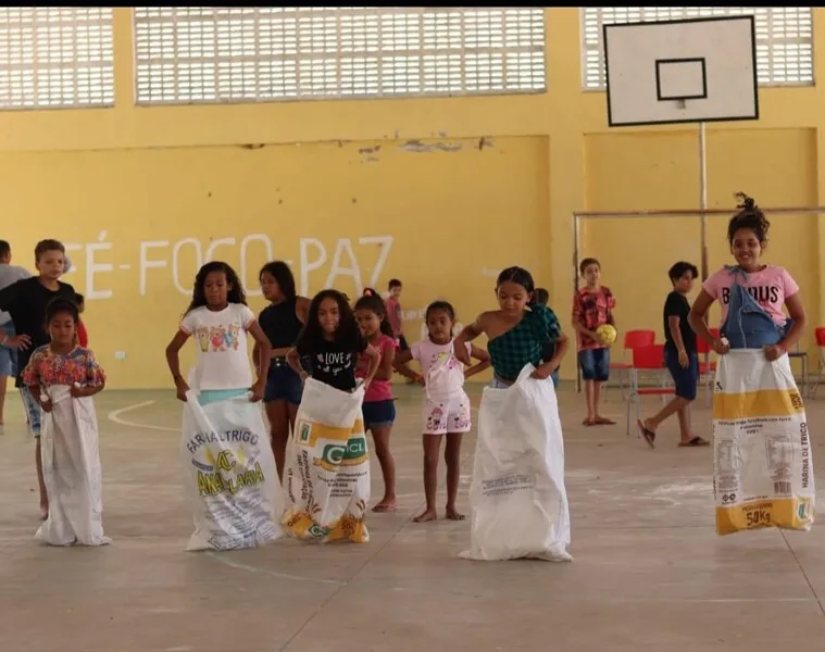 Diversão: nessa disputa, as crianças seguram o saco com uma mão para evitar que ele caia abaixo dos joelhos