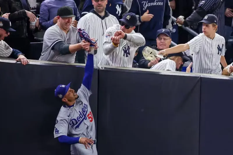 Torcedores do Yankees tentam tirar bola do jogador dos Dodgers