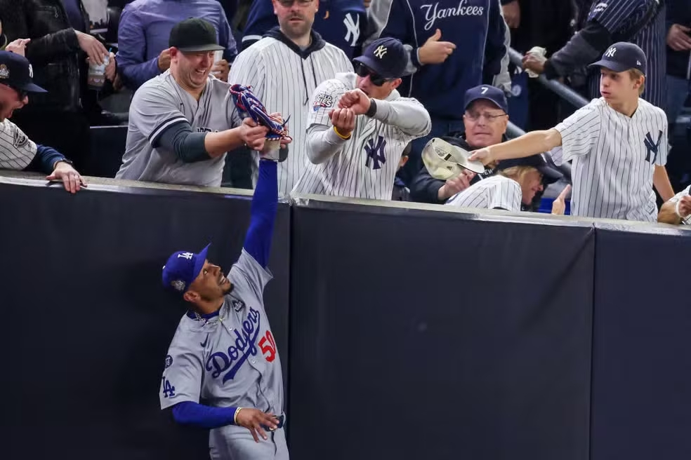 Torcedores do Yankees tentam tirar bola do jogador dos Dodgers