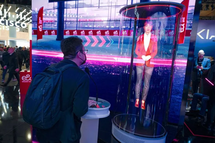 Homem interage com holograma com IA em estande do MWC (Mobile World Congress)