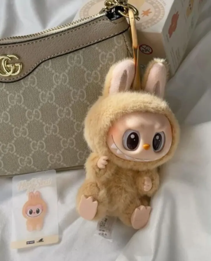 Bonecos de pelúcia são pendurados nas bolsas e fazem sucesso