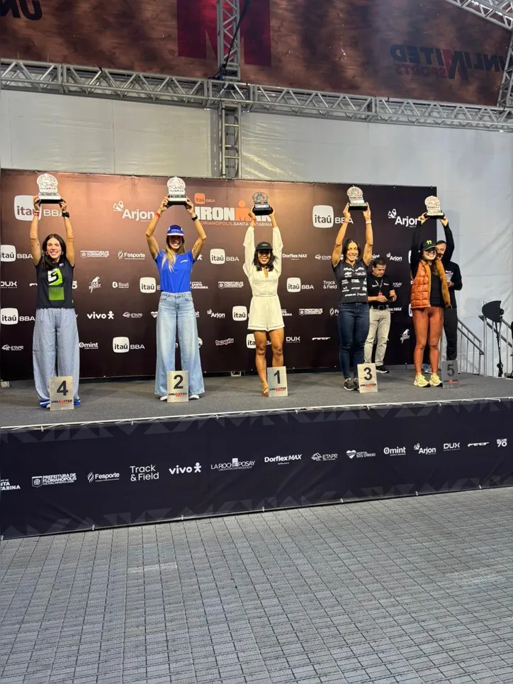 Amanda (à esq) no pódio, ao receber o troféu