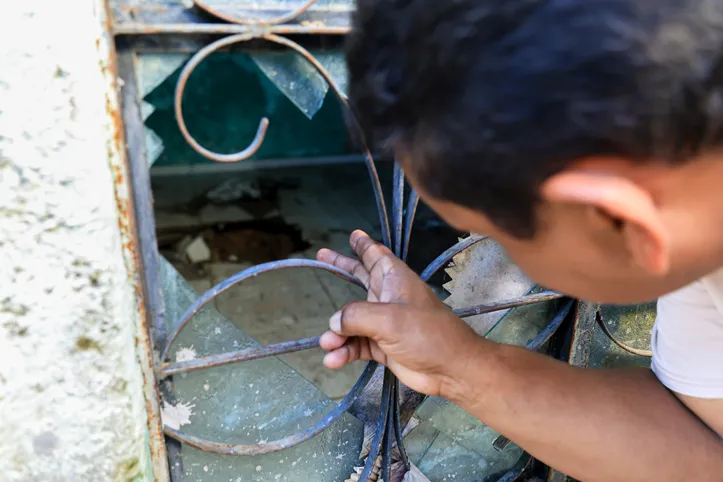 Morador mostra buraco formado em uma casa na rua que vive
