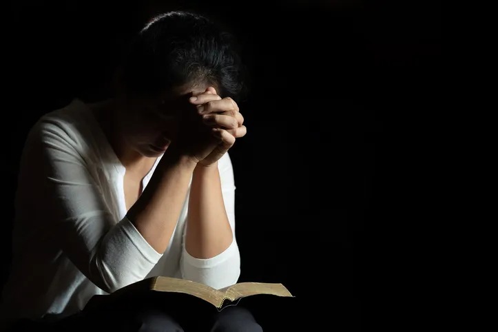 Oração com as mãos sobre a Bíblia