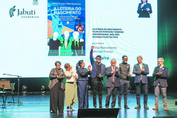 Fillipi Nascimento, ao centro, após receber o prêmio Jabuti Acadêmico 2026